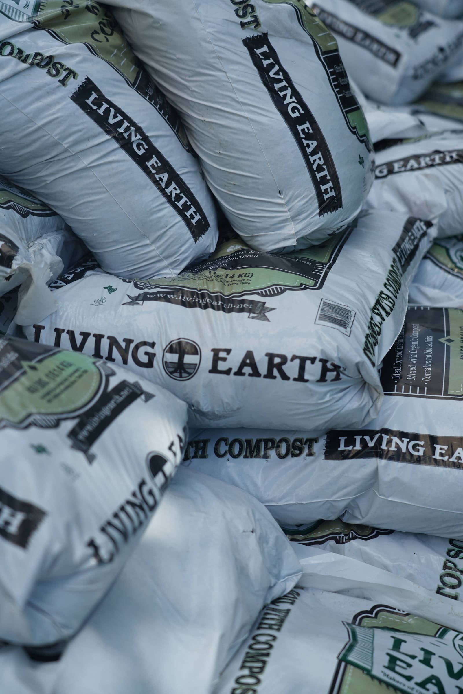 A stack of white compost bags in the shade